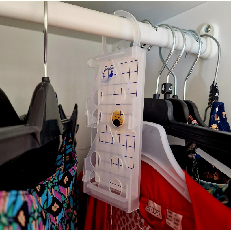 Piège PYRO NET anti mite vêtement installé dans une penderie remplie de vêtements.