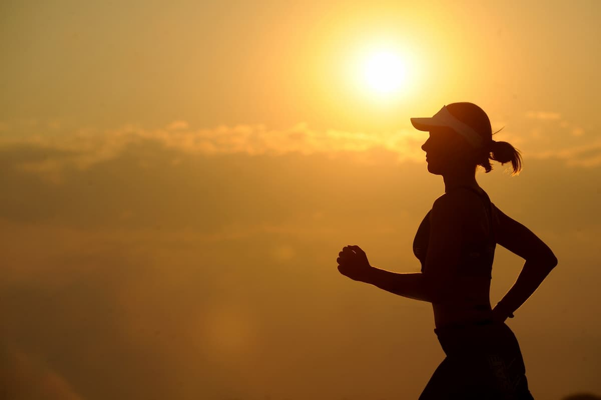 Femme pratiquant la course à pied au coucher du soleil