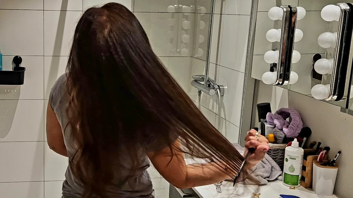 Femme se brossant ses cheveux mouillés dans sa salle de bain